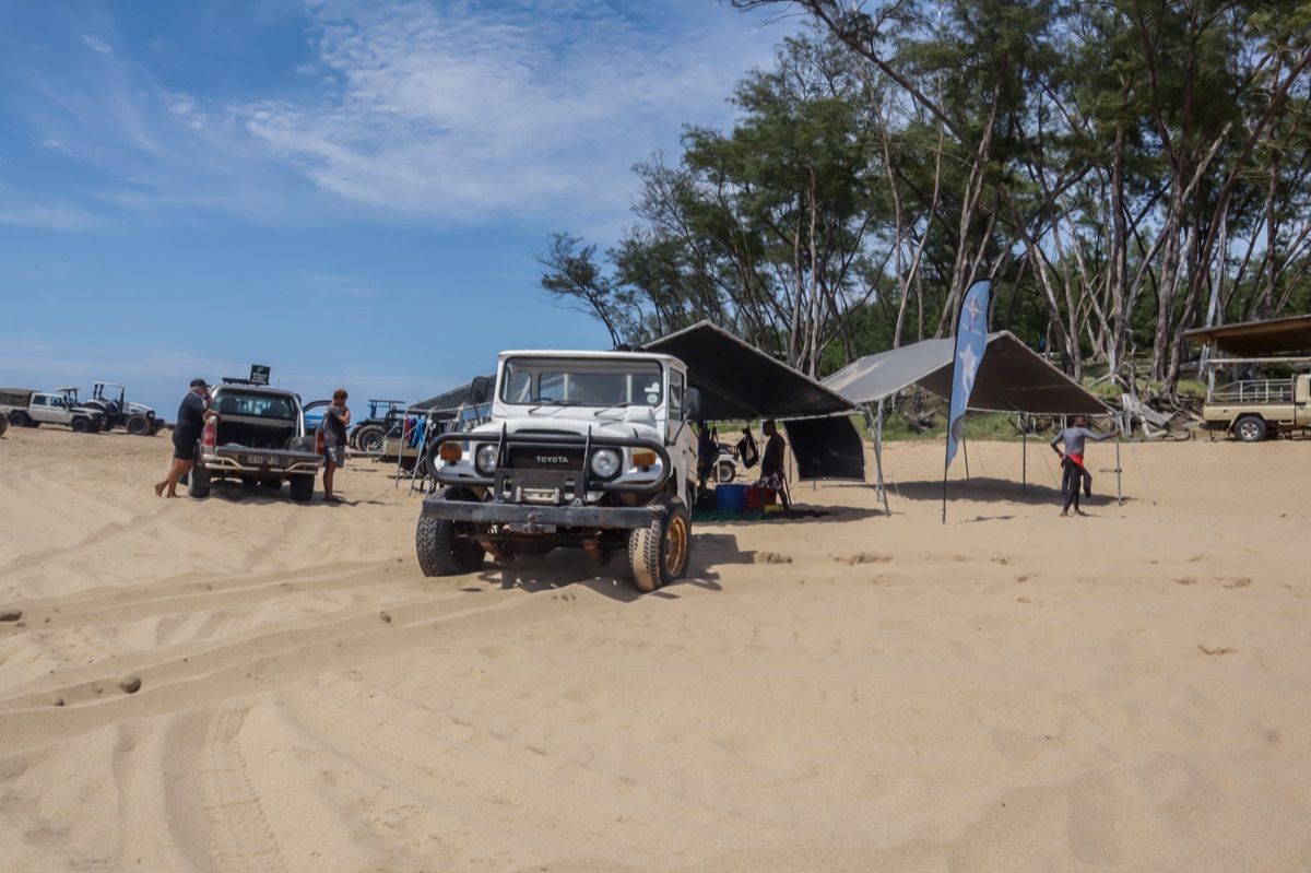 Safari camp with tents and a vehicle